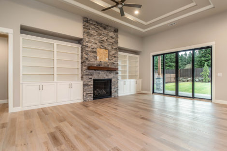 Heights at Pleasant Valley Lot 2 Great Room with Stone Face Fireplace, built-in shelving, and doors to access patio and backyard