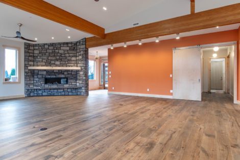 Courtney Acres Lot 3 Great Room with Stone Face Fireplace, Sliding Barn Door, and Vaulted Wood Beam Ceiling
